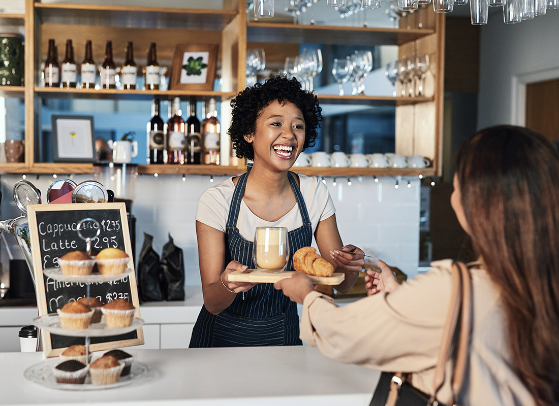 Business Insurance - Friendly Cafe Worker Serving a Customer